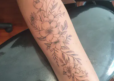 Tatouage floral en fine line, fleurs sauvages sur l'avant-bras