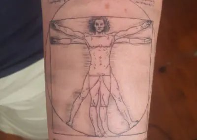 Tatouage de l'Homme de Vitruve en fine line sur le bras